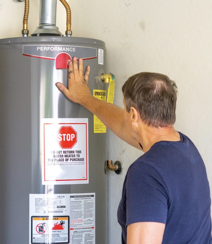 Adult male with hand on newly installed hot water heater
