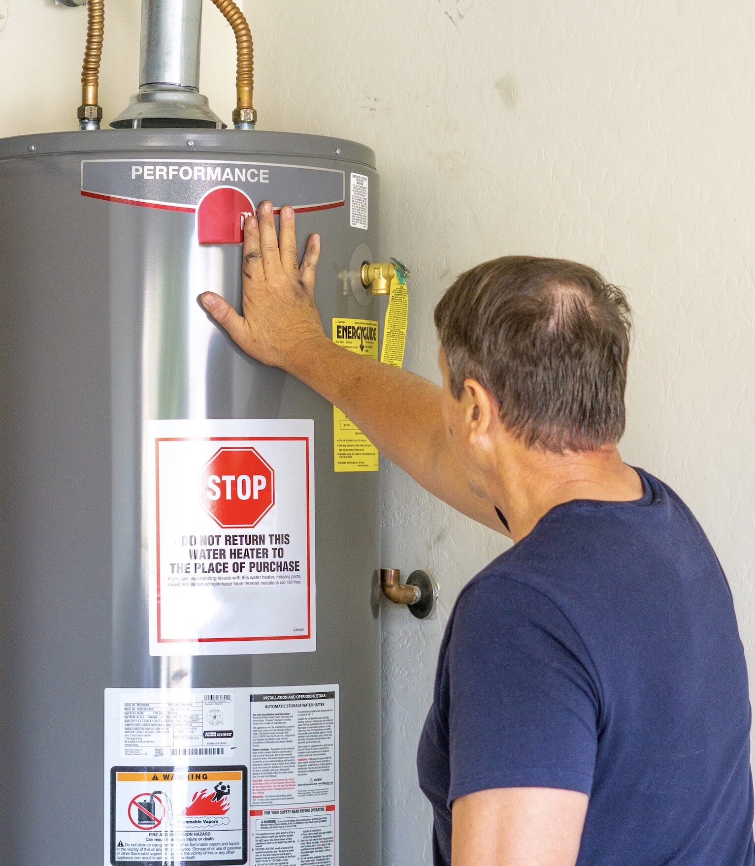 Adult male with hand on newly installed hot water heater
